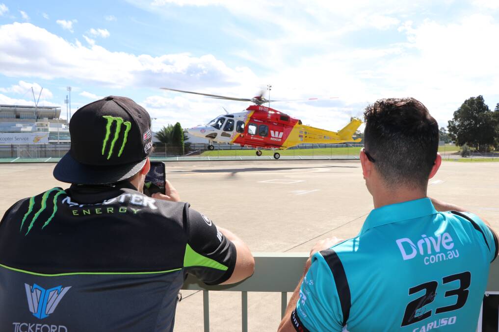 UP AND AWAY: Waters and Caruso watch the Westpac Rescue Helicopter take off. Picture: Supplied. 