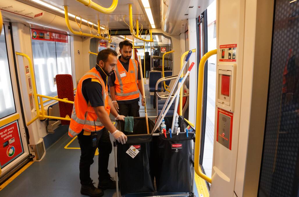 SQAFETY: Cleaners on a Newcastle tram on Saturday. Picture: Max Mason-Hubers