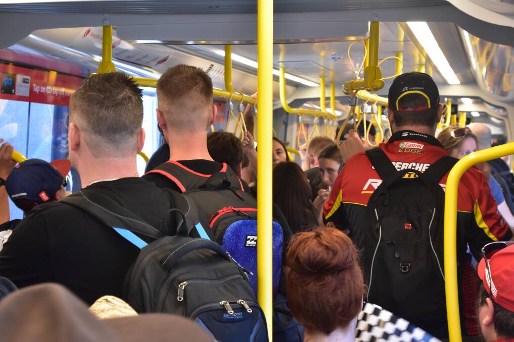 TIGHT SQUEEZE: Supercars fans on a Newcastle tram on Friday morning. 