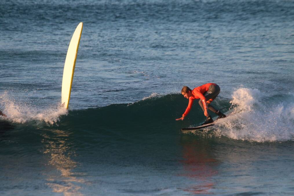 FUN: A surfer and a lost board at Bar Beach on Tuesday. Picture: Dave Anderson 