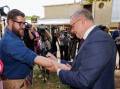 Anthony Albanese signs a GST pledge on the arm of reporter Dylan Caporn. Picture by Richard Wainwright/AAP PHOTOS