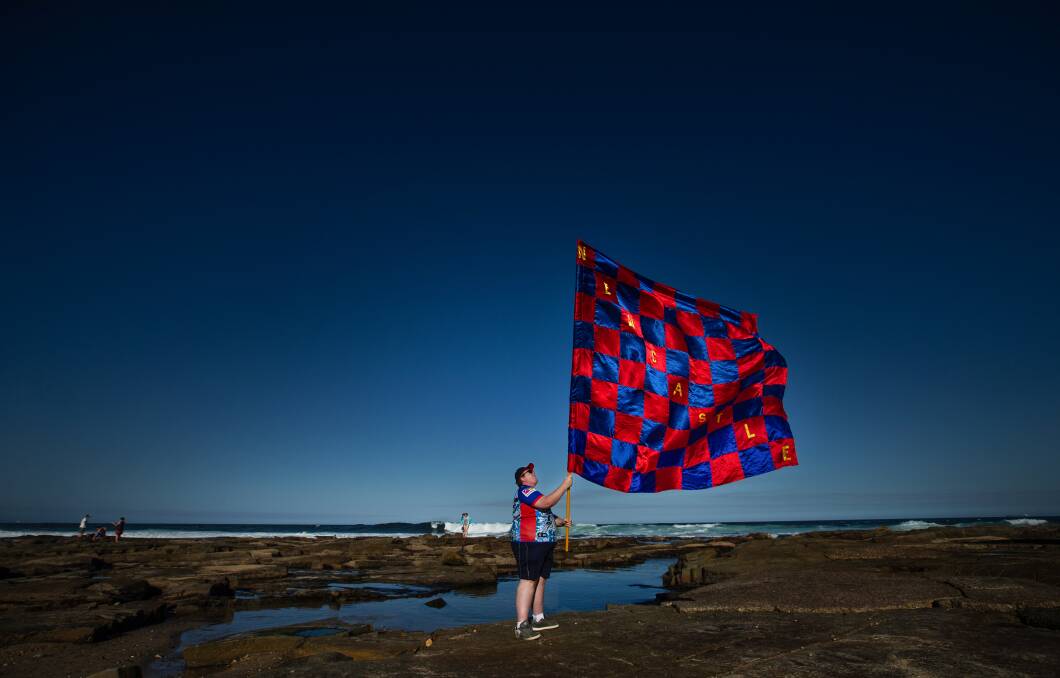 Damian McFarland of Gateshead is the bearer of the big Newcastle Knights flag. Taking it for a spin at Merewether Ocean Baths. Picture: Marina Neil