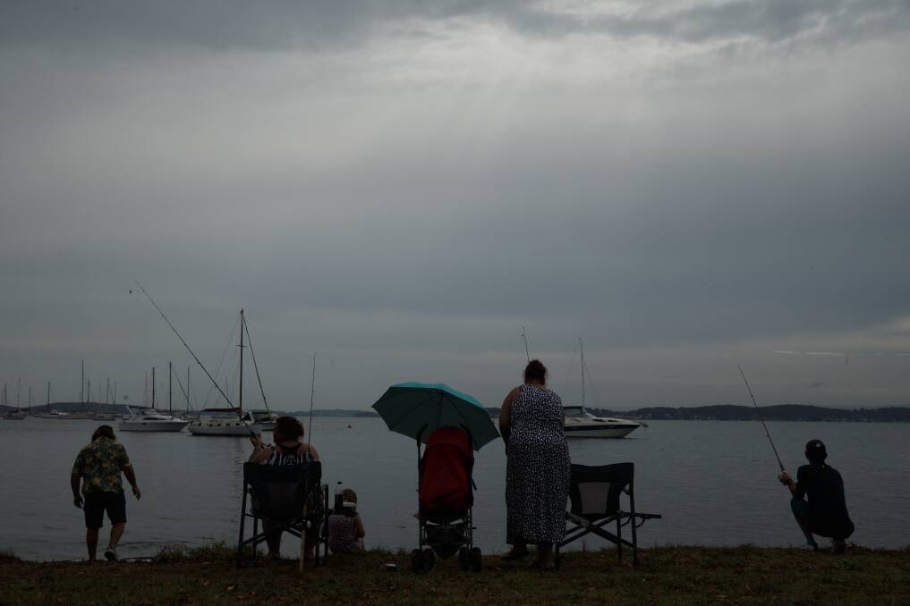 GREY SKIES: The Bracken-Hayes family of Manilla fishing a Belmont an inland storm cell rolls overhead bringing rainfall to Lake Macquarie and much of the Hunter on Thursday. Photo: Max Mason-Hubers