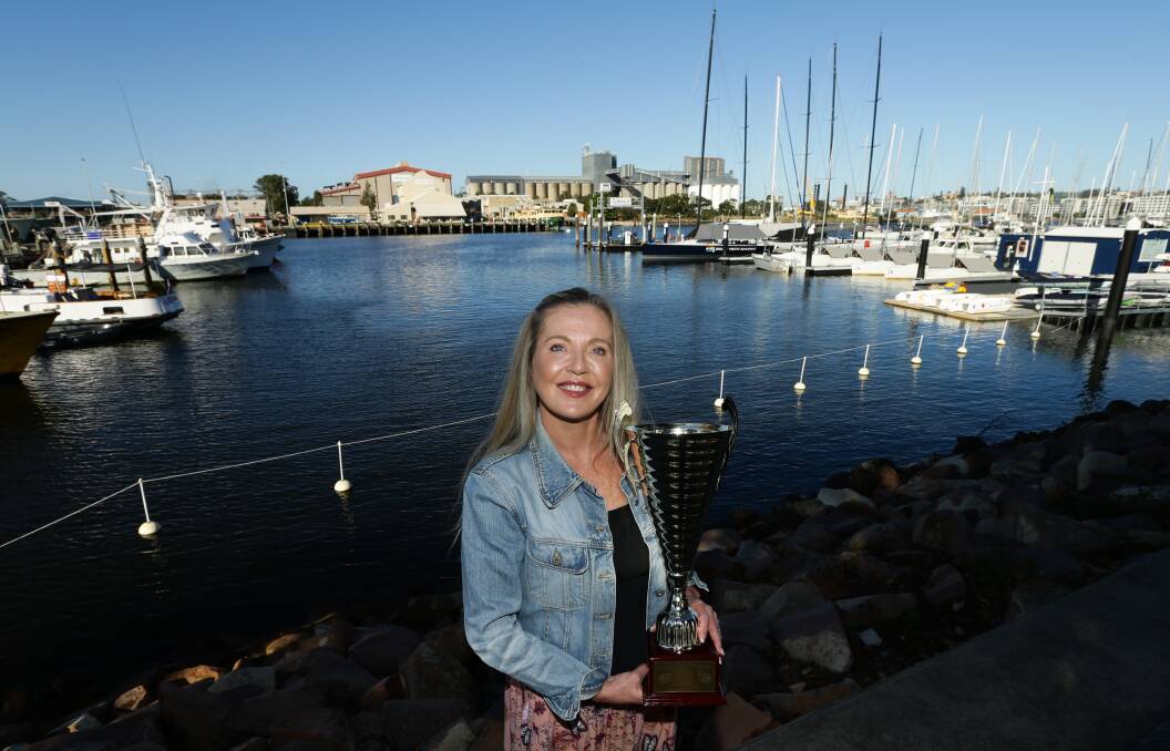 FASTEST GUN: Karen Milner of Merewether was awarded the inaugural prawn peeling championship trophy after setting a blistering pace for peeling 12 king prawns in just 74 seconds at the first Newcastle Seafood Festival at the weekend. Picture: Jonathan Carroll