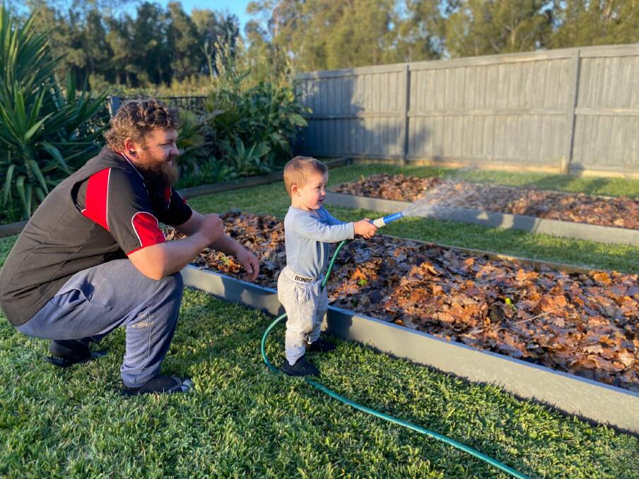 Mark Papworth and son Zane, 2, water the garden at their Rutherford home. 