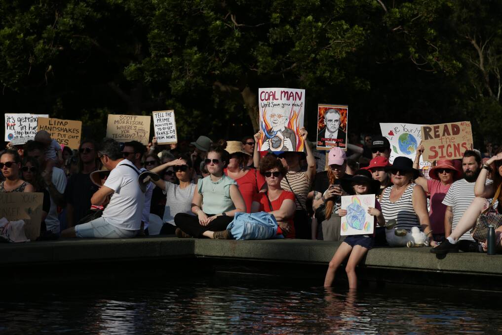 'READ THE SIGNS': Demonstrators bore hundreds of placards calling denouncing government inaction on climate change. Photo: Simon de Peak