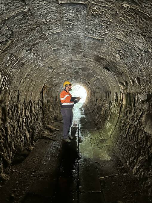 A state transport department ecologist inspects a culvert for presence of microbats near the Singleton Bypass project.