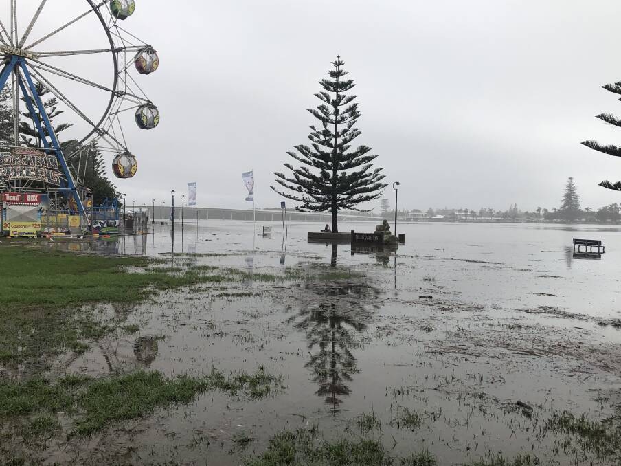 Flood: A flooded Tuggerah Lakes at The Entrance leaves a theme park under threat and the boardwalk submerged on Monday. 