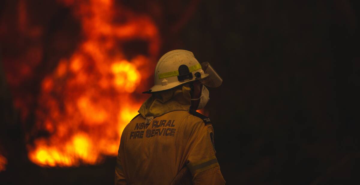 Warning: A Rural Fire Service volunteer at a ferocious Charmhaven fire on New Year's Eve, during a catastrophic Australian summer fire season. Picture: Marina Neil. 