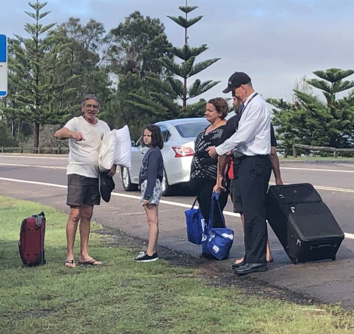 Stranded: North Entrance residents on the side of the Central Coast Highway on Monday morning after a swollen Tuggerah Lakes trapped flood water on the North Entrance peninsula and caused the worst flooding in decades.