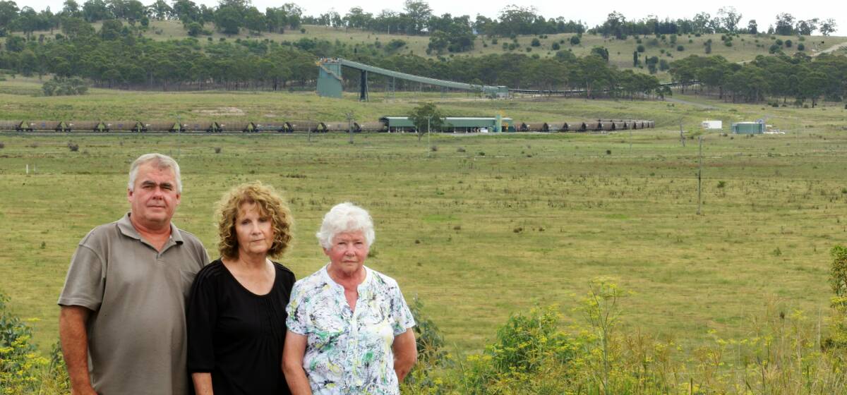 Proximity: Peter and Julie Brown and Mr Brown's mother June with Mangoola coal mine infrastructure and a coal train in the background.
