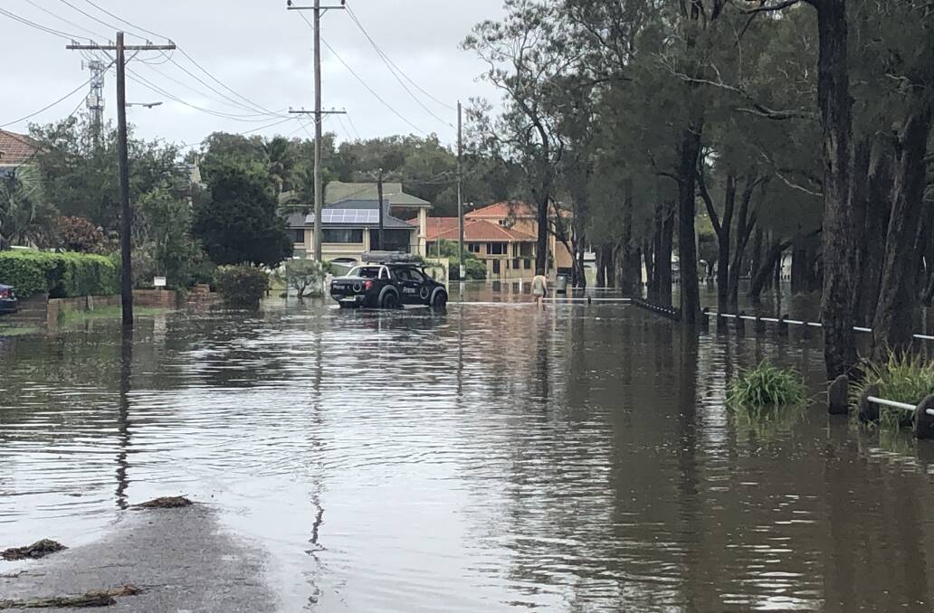 Flooded: A street at Long Jetty completely overwhelmed by flood water on Monday.