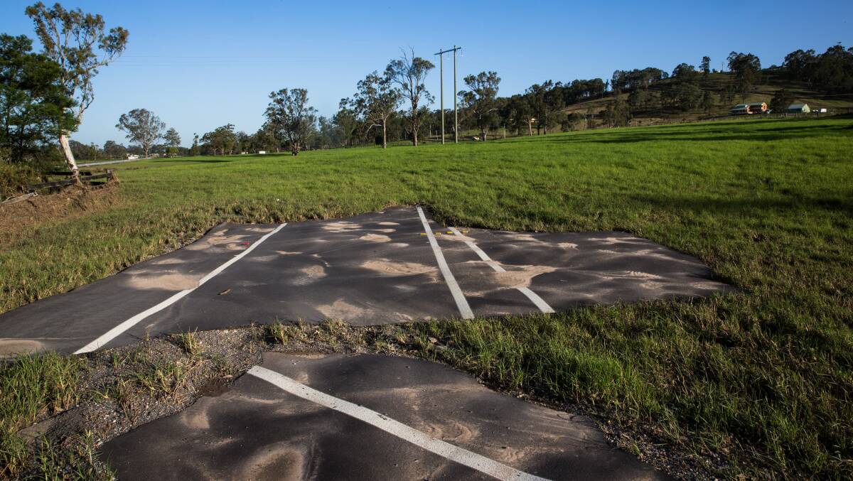 Damage: A section of road carried into a Dungog paddock after devastating flooding in 2015. 