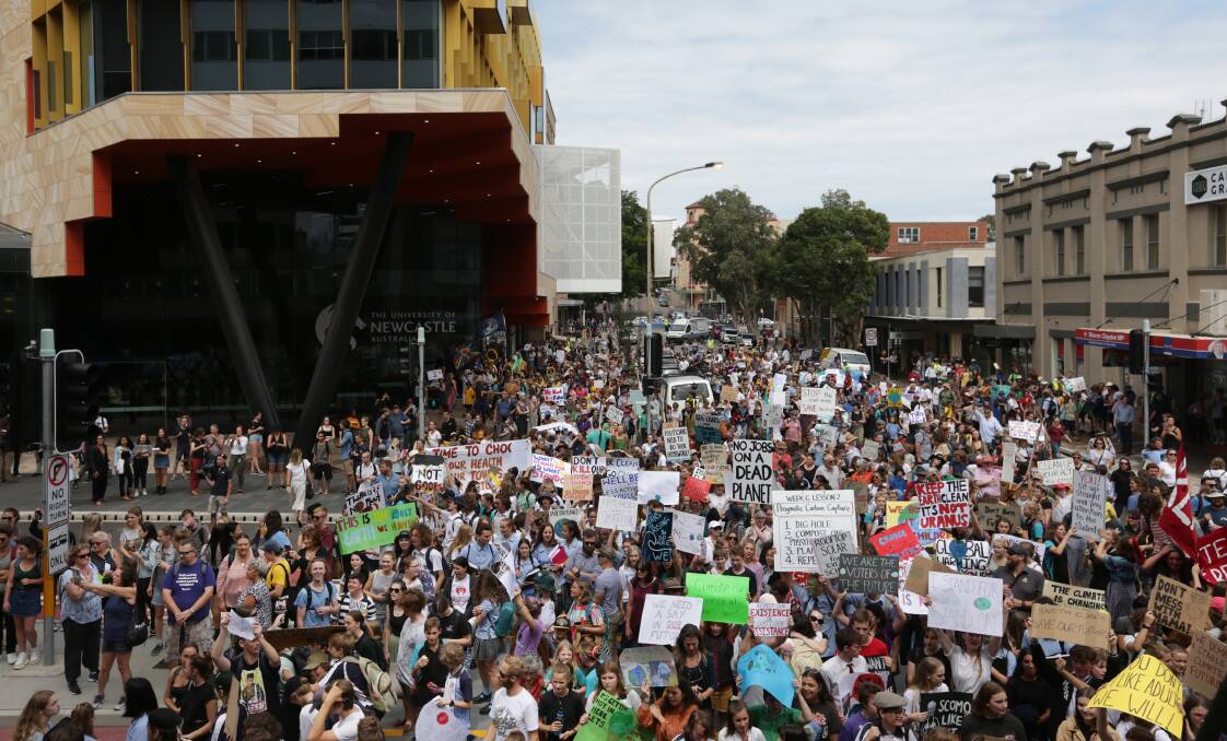 Action: Thousands march in front of the University of Newcastle's NewSpace building in March during the school strike for climate action rally. Picture: Simone De Peak. 