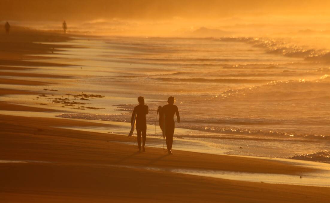 GLOW: Morning surfers on the beach on Wednesday. Picture: Dave Anderson
