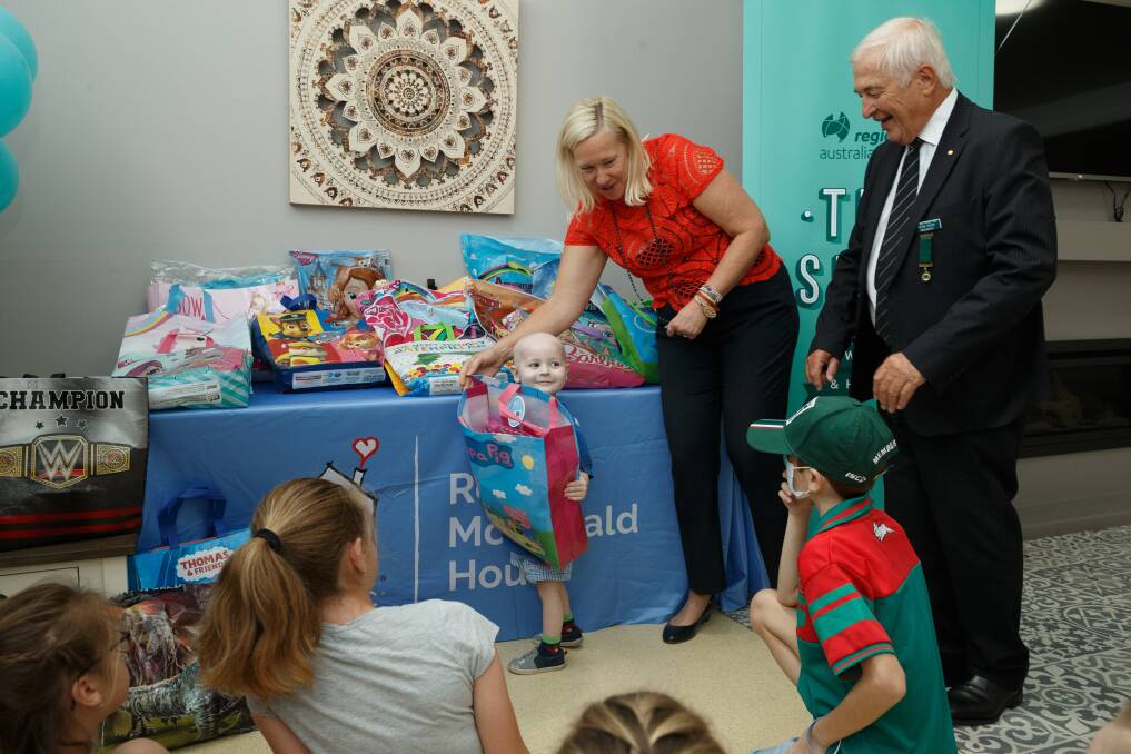 IN THE BAG: Three-year-old Sam Hope gets in early to get a showbag for his sister, Haidee, with Newcastle Regional Show's Peter Evans and Kim-Cherie Davidson. Picture: Max Mason-Hubers 