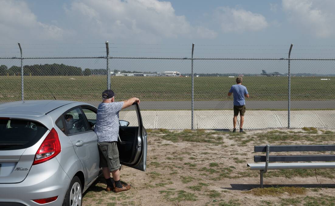SPECTATORS: Charles Mika and Phillip Sutton watch exercises from outside Williamtown RAAF base. Picture: Max Mason-Hubers