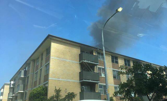 UNINHABITABLE: Images from the scene of the fire, captured by a witness, showsmoke billowing from a third-floor Merewether apartment. Photo: contributed.