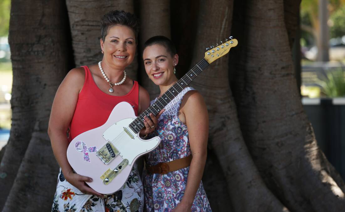 JAMMING: Kerrie Turner, right, and Brooke Procter, who was diagnosed with breast cancer in 2017, with a guitar made and donated by Greg Franks. Picture: Simone De Peak 