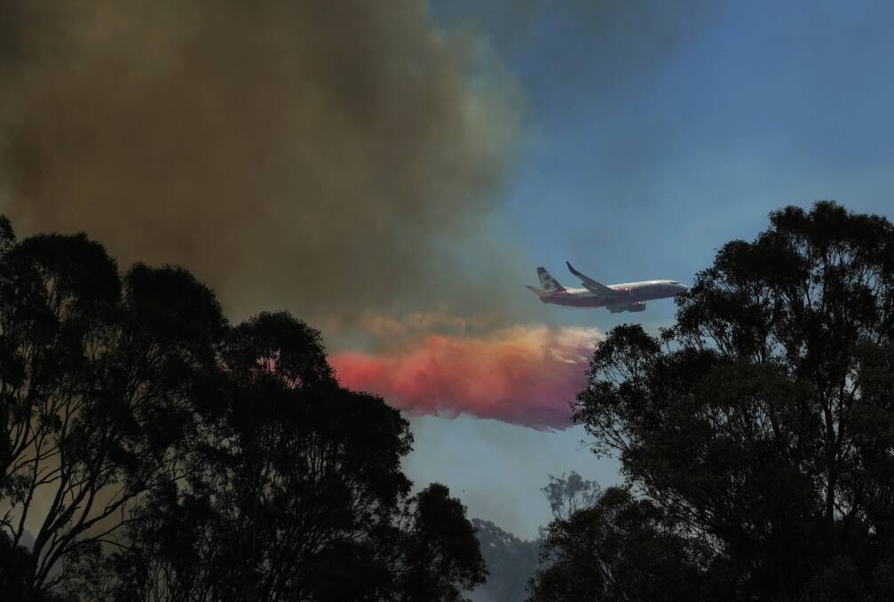 BUSHFIRE: Fire retardant being dropped over Greta on the second day of bushfires in the town on November 13. Picture: Simone De Peak