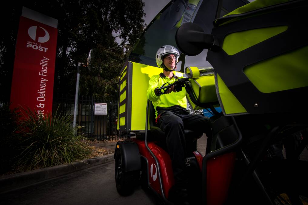 WHEELS: Long-time postie Steven Richards with one of the electric delivery vehicles in October, 2017, when the bikes were first trialled in Newcastle. Picture: Simon McCarthy 