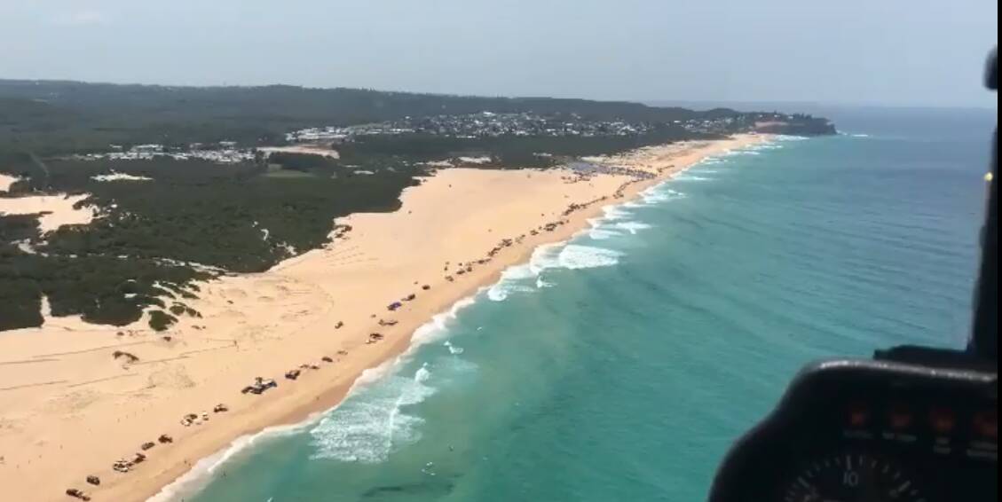 LINE UP: A thumbnail from video footage captured by Heliservices Newcastle showing four-wheel drives along Nine Mile Beach on Australia Day. Picture: Heliservices Newcastle 