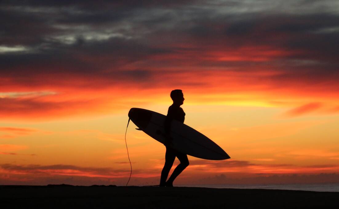 STUNNER: A surfer soaks up the sunrise on Monday. Picture: Dave Anderson