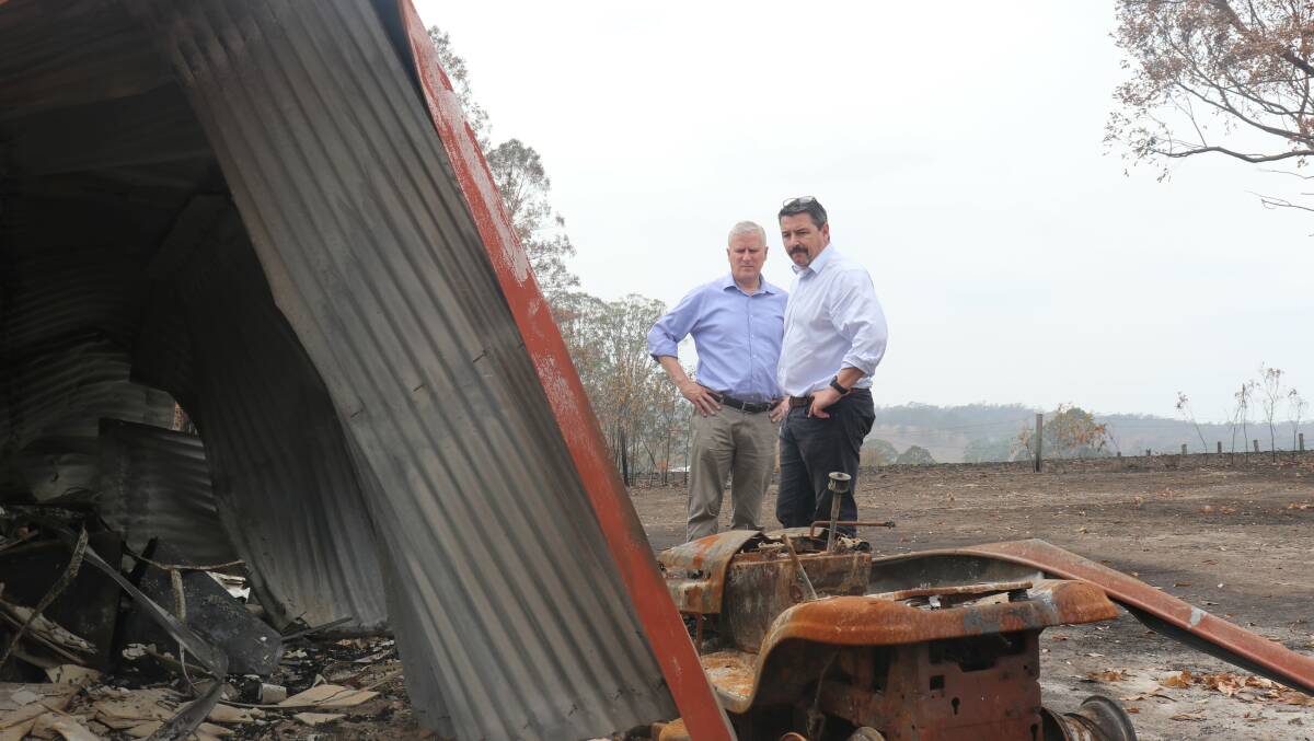 Member for Cowper Pat Conaghan inspects a home destroyed by fire at Willawarrin.