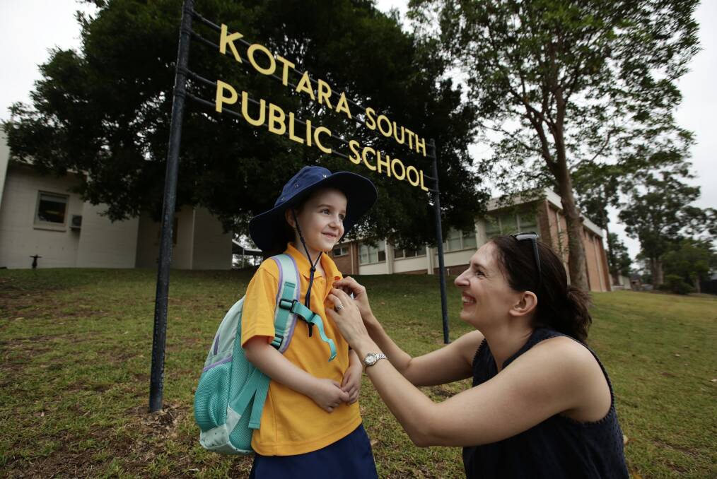 PROUD MOMENT: Sarah Layzell adjusting the name badge of daughter Sophia, 6, as she heads in for her first day of Kindergarten. Picture: Simone De Peak