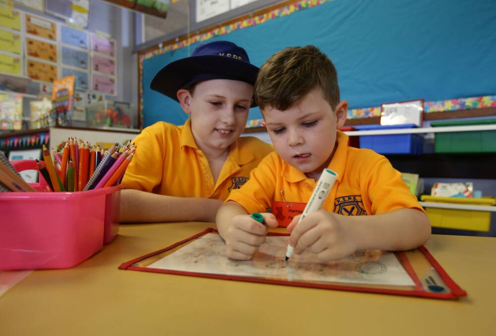 FRIENDS: Harrison Ferris, 5, on his first day at kindergarten with his Year 5 buddy Lucas O'Connor at Kotara South Public School on Wednesday. Picture: Simone De Peak