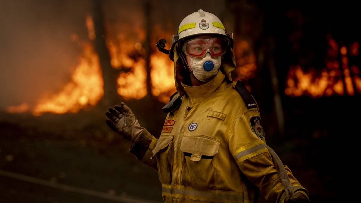An RFS volunteer works to battle a bushfire on Murramaranf Road in Bawley Point in December. Photo: Sitthixay Ditthavong
