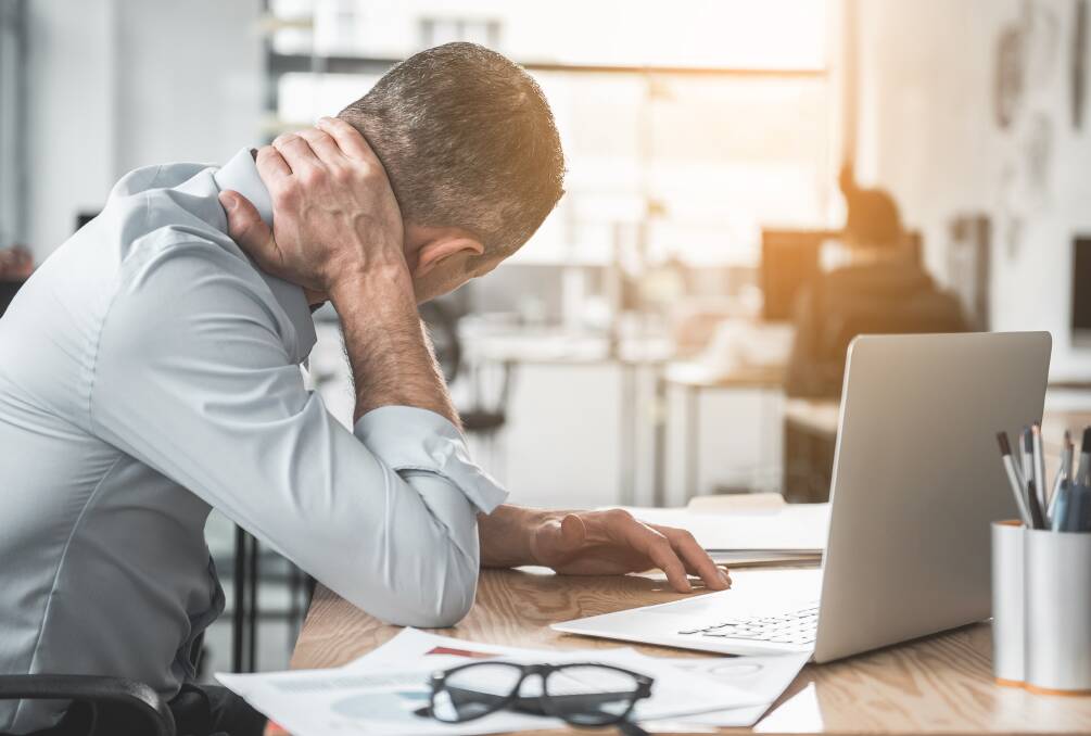 Working at a desk is a common cause of neck pain. Photo: Shutterstock