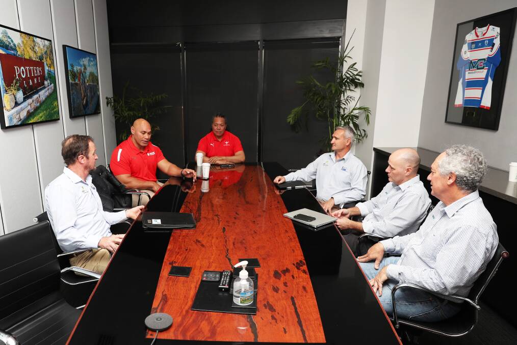 Sione Finefeuiaki, second from left, speaks with fellow supporters of the Tongan clean water project at the offices of the McCloy Group. Picture: Peter Lorimer