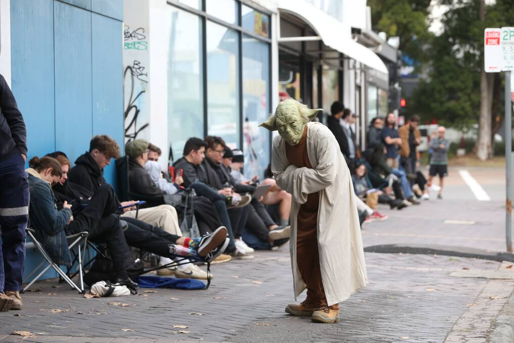 A queue of people - and Yoda - wait for the doors to open on the annual "May the Fourth Be With You" sale at Muso's Corner. Picture: Marina Neil 
