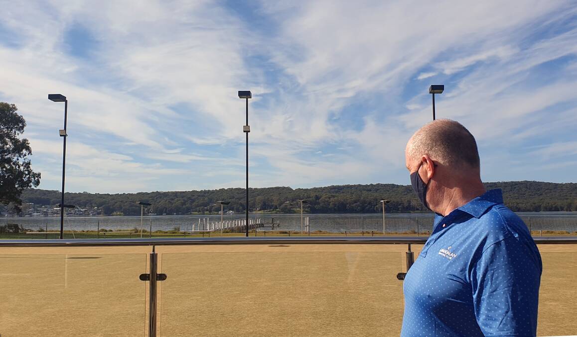 SHUT: Gwandalan Bowling Club CEO Steve Rigney looks over the empty greens towards Nords Wharf, which is not in lockdown, on the distant shore. Picture: Cathy Papesch
