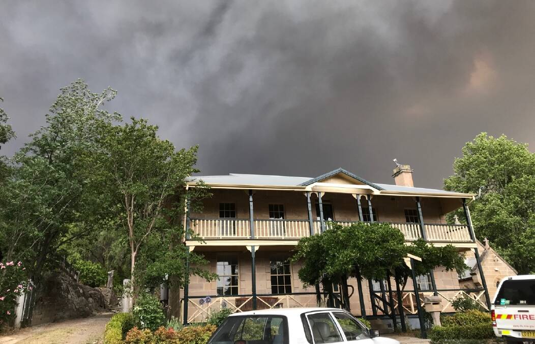 THREAT: Bushfire smoke above brigade member Tony Thornton's historic home in the main street of Wollombi in December. Picture: Supplied