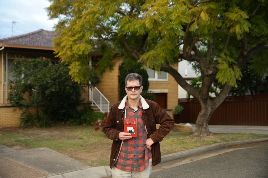 John Hughes holds a copy of "The Idea of Home" outside his family home in Cessnock. Picture: Jonathan Carroll