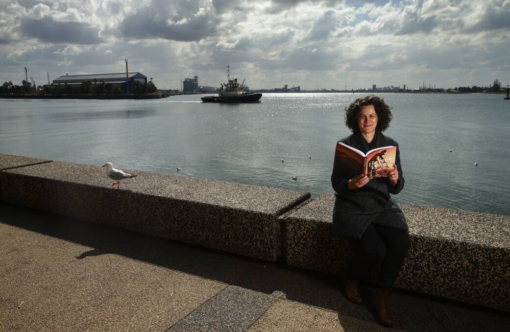 WATER AND WINE: Author and historian Julie McIntyre by Newcastle Harbour, with a copy of her new book, "Hunter Wine". Picture: Jonathan Carroll