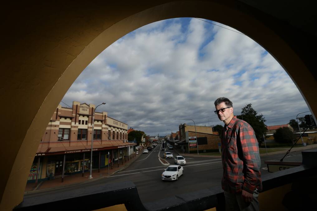 HOMETOWN: Award-winning author John Hughes, photographed in 2020, overlooking Vincent Street, Cessnock, where he grew up and has drawn inspiration for his writing. Picture: Jonathan Carroll