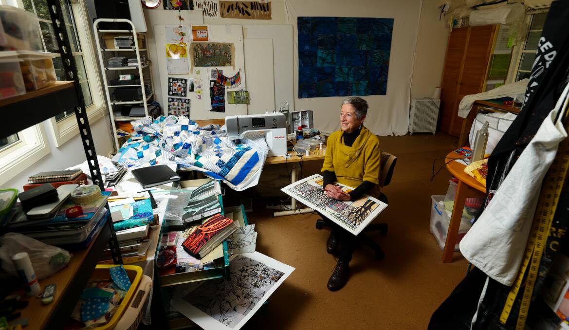 QUILTING CENTRAL: Judy Hooworth amid the stacks of textiles and her photo albums and sketch books in her home studio at Morisset. Picture: Jonathan Carroll