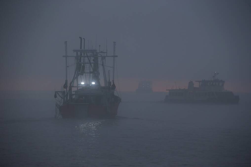 A trawler approaches the Stockton ferry on a foggy Newcastle harbour. Picture: Simone De Peak