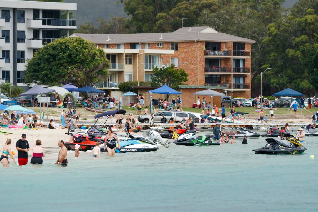 SUMMER CROWDS: Holidaymakers on the sand at Little Beach, and in the units behind, at Port Stephens. Picture: Max Mason-Hubers