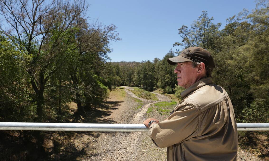 Peter Lawrence looks over a dry section of the Allyn River, near his farm. Picture: Simone De Peak