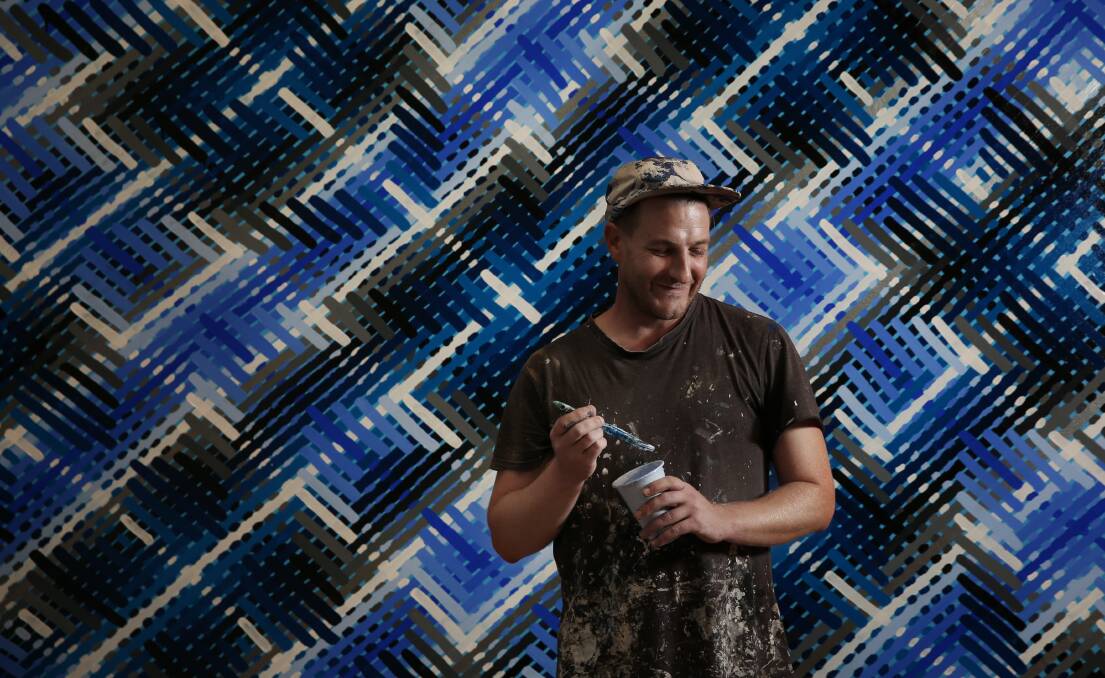 BRUSHING THE BLUES: Lucas Grogan stands in front of one the murals he is painting at Maitland Regional Art Gallery for his exhibition, 'Long Story Short'. Picture: Simone De Peak