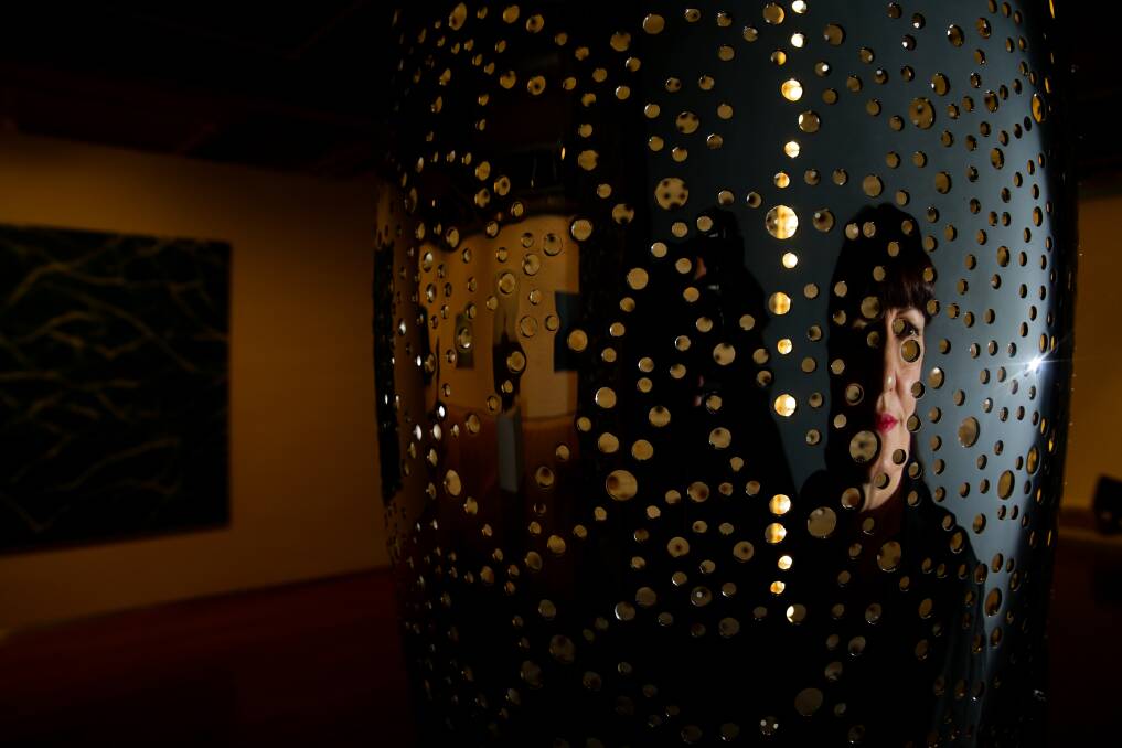 REFLECTING: Newcastle Art Gallery director Lauretta Morton peers into "The First Immeasurable - Love (an unbounded heart)", by Lindy Lee. Main Pictures: Jonathan Carroll