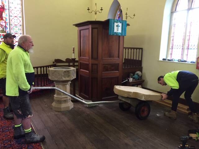 The team of stonemasons moves the memorial stone to its new position in the church. Picture: Courtesy, Jonathan King 