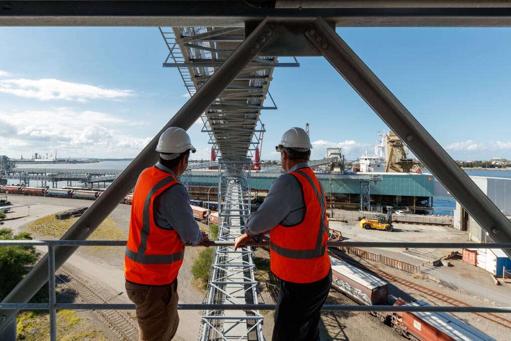 Co-CEOs of Newcastle Agri Terminal, Jock Carter and Martin MacKay, watch the loading of wheat onto a ship at their Carrington facility. Picture: Max Mason-Hubers
