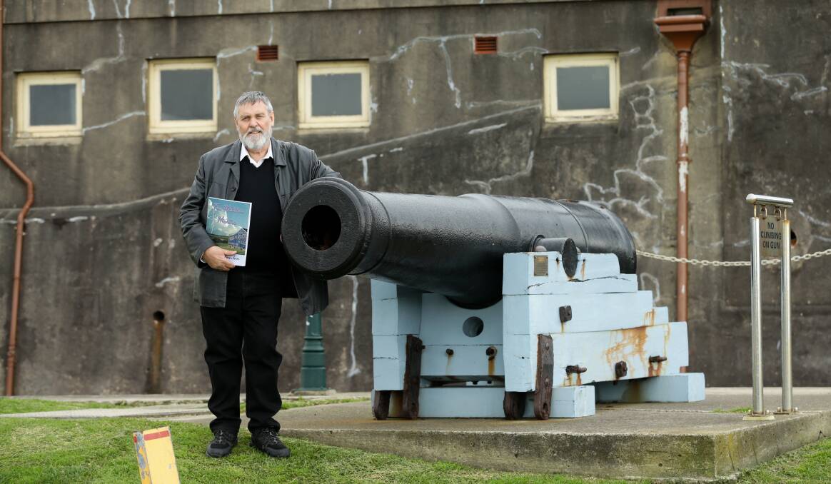 TOUCHING THE PAST: Author Mike Scanlon, holding his new book, with a historic cannon at Fort Scratchley.