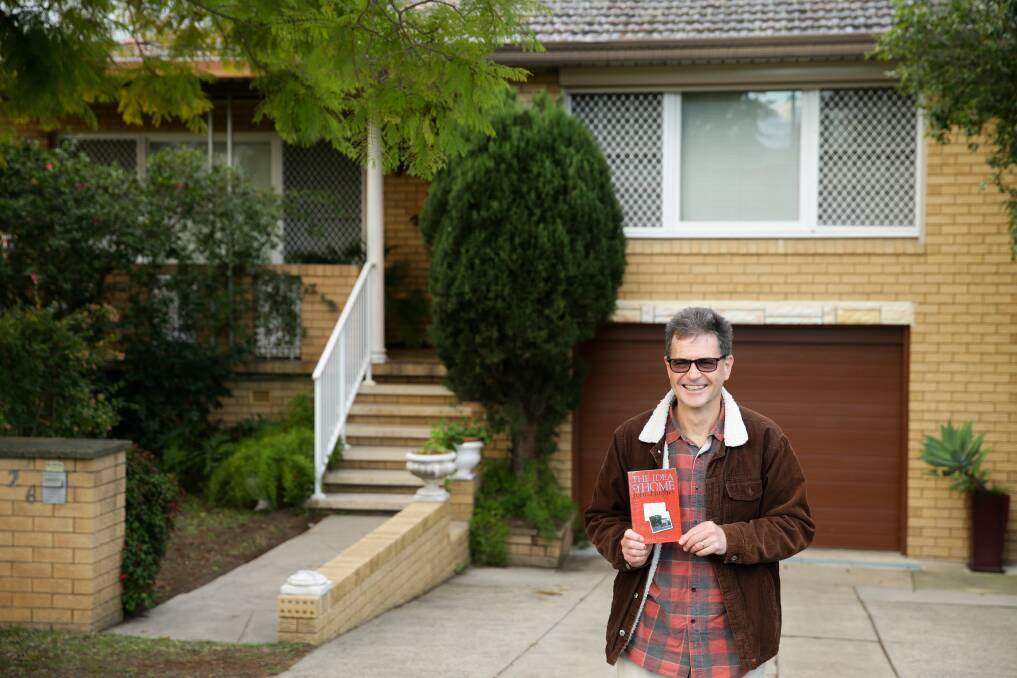 Author John Hughes holding a copy of "The Idea of Home" outside the family home in Cessnock. Picture: Jonathan Carroll