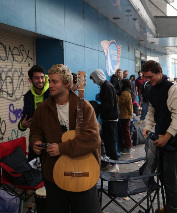 Justin Mills in the queue with his guitar. Picture: Marina Neil